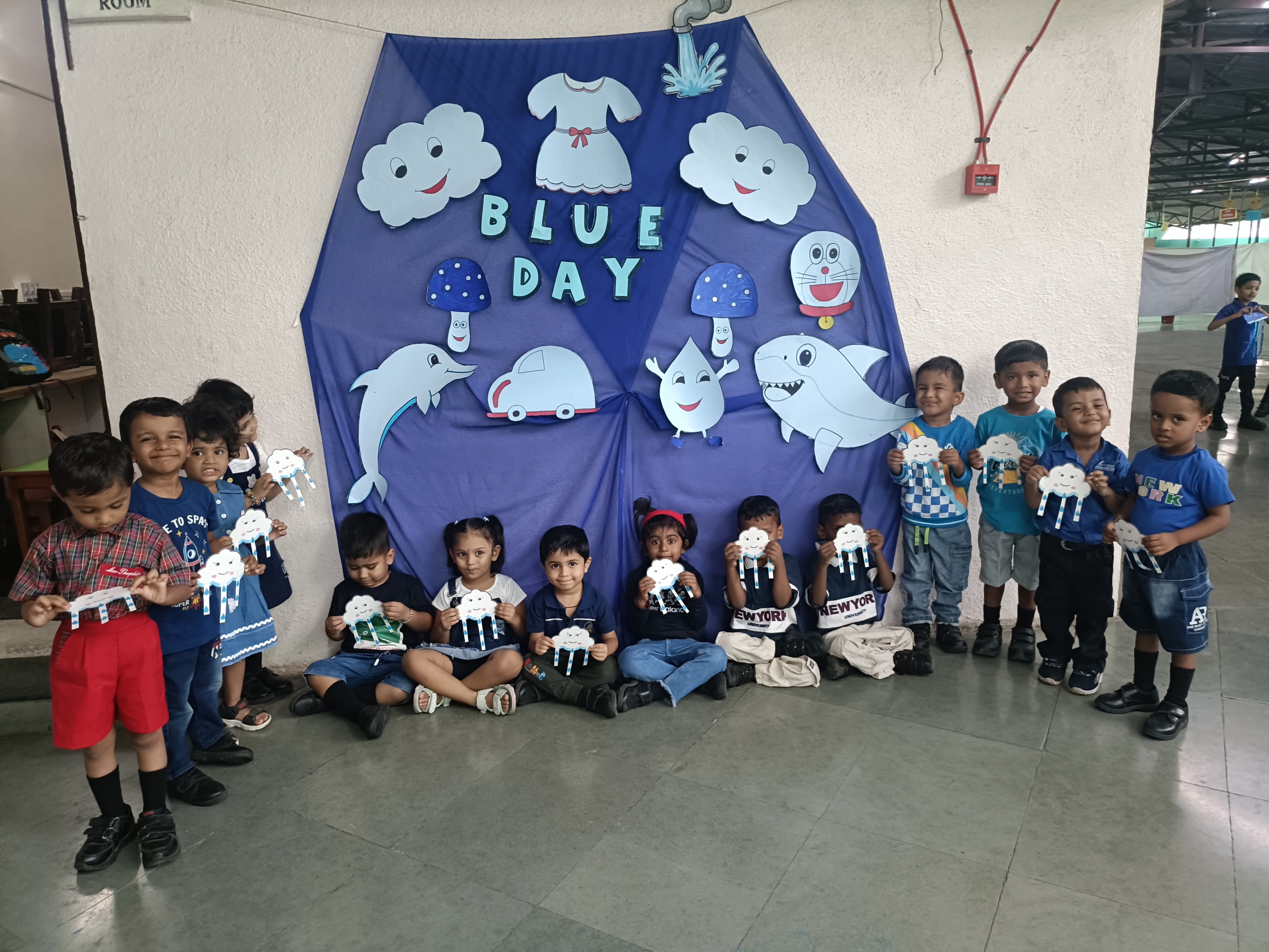 Group - Blue Day theme board and students posing